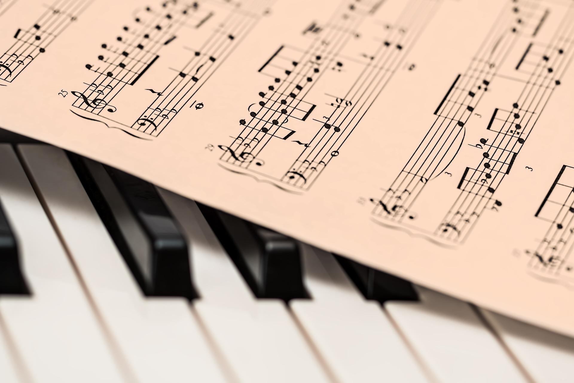 Das Bild zeigt einen Ausschnitt einer Klaviertastatur auf der Noten liegen.