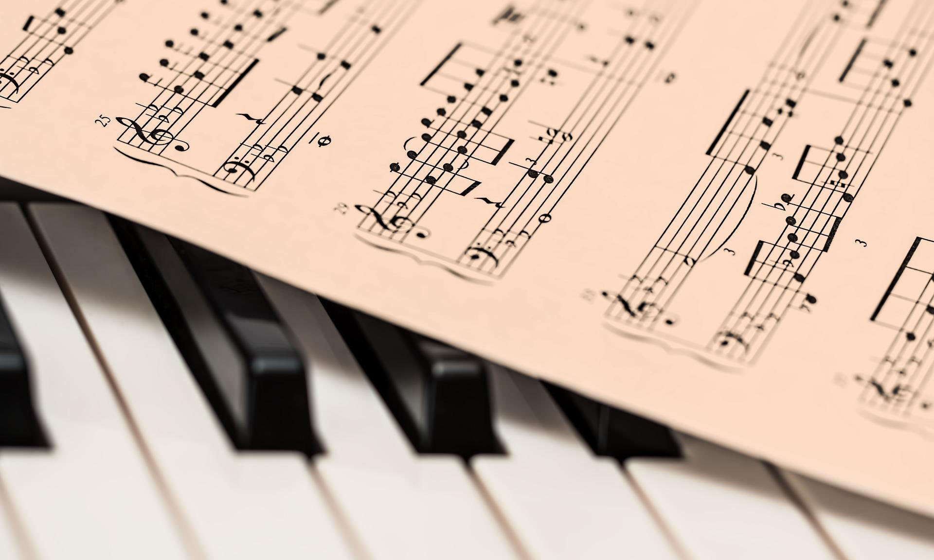 Das Bild zeigt einen Ausschnitt einer Klaviertastatur auf der Noten liegen.